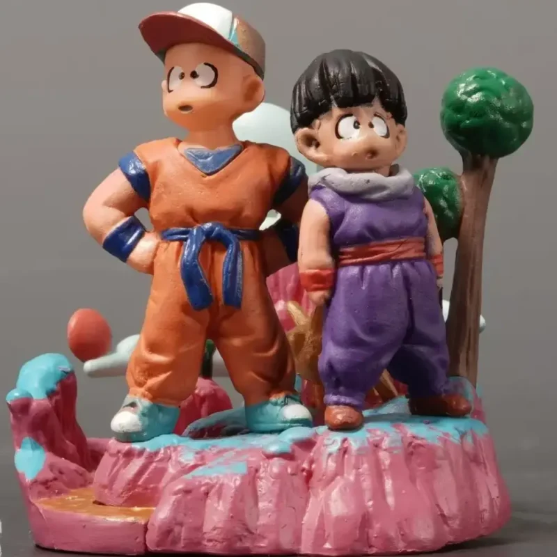 Alt text: Dragon Ball Krillin and Gohan detailed figurines in vibrant orange and purple battle suits, dynamic poses with colorful pink terrain and green trees background.