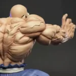 Detailed Dragon Ball Statue with exaggerated muscles, dynamic martial arts pose, and blue gi attire on dark plain background.